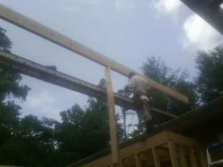 Carpenter setting a ridge beam over a new addition frame — Ice Dam Removal by Roofing Brothers in Elgin