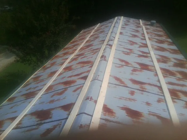 Rusted metal roof panels with new wood purlins before replacement — Storm Damage Roof Repair in Elgin by Roofing Brothers